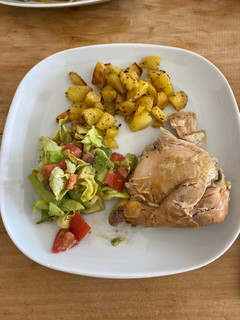 A picture of Roasted chicken with potatoes and salad.