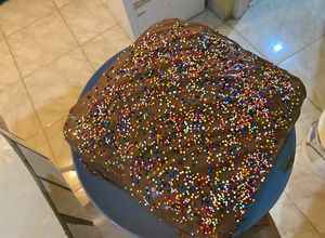 Una foto de Pastel de chocolate relleno de dulce de leche y ganache de chocolate con sprinkles