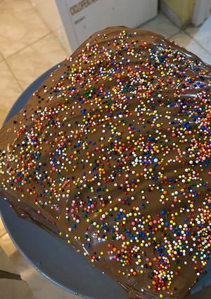 Una foto de Pastel de chocolate relleno de dulce de leche y ganache de chocolate con sprinkles