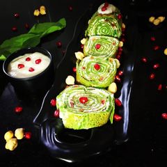 A picture of Spinach Crepe Rolls with Chickpea filling served with Banana sauce.