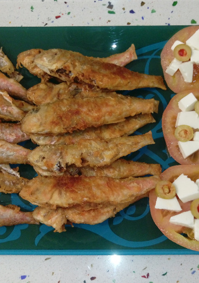 Una foto de Salmonetes fritos y tomates con queso y aceitunas