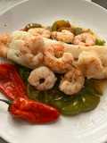 Bacalao skrei con gambones al ajillo, sobre cama de pimientos