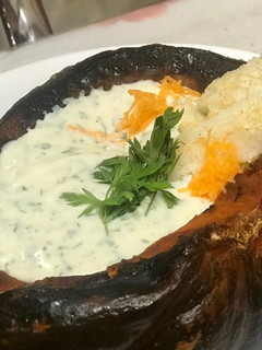 Una foto de Zapallo relleno con dip de queso crema y hojas de zanahoria