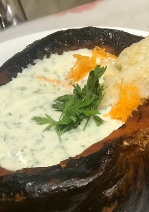 Una foto de Zapallo relleno con dip de queso crema y hojas de zanahoria