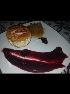 Una foto de Rulo de cabra frito con mermelada de arándanos y cebolla caramelozada