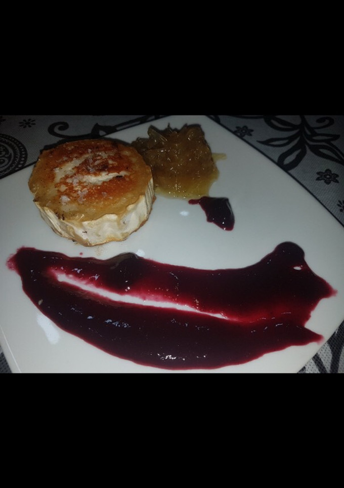 Una foto de Rulo de cabra frito con mermelada de arándanos y cebolla caramelozada