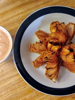A picture of Baked blooming onion and dipping sauce.