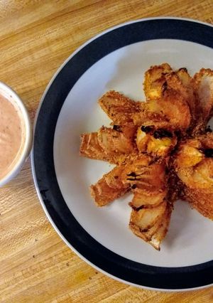 A picture of Baked blooming onion and dipping sauce.