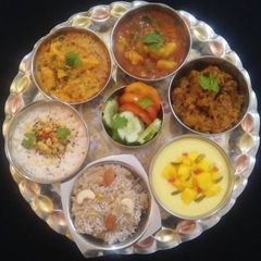 A picture of Indian Veg Thali (Aloo, Paneer, kaddu, Raita, Halwa, Shrikhand).
