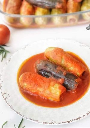 A picture of Stuffed zucchini and eggplant in tomato sauce.