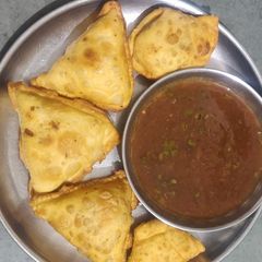 A picture of Samosa with chutney.