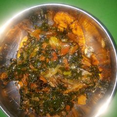 A picture of Fried plantain and water leaf stew.