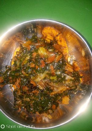 A picture of Fried plantain and water leaf stew.