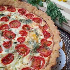 A picture of Crème fraiche quiche with pesto and veggies.