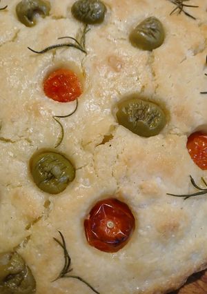 Una foto de Focaccia con tomates cherry, aceitunas y romero