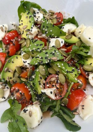 Una foto de Ensalada de rúcula, tomate, palta y queso