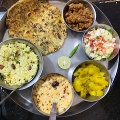 A picture of Yummy lunch platter makki roti, kaddu sabzi, fried rice, raita.