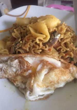 A picture of Sardine Noodles with cooked macaroni and fried egg.