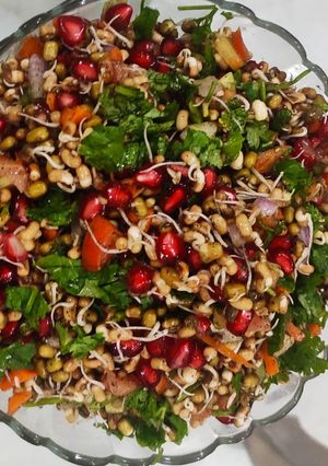 A picture of Mixed sprouts and veggies salad with pomegranates.