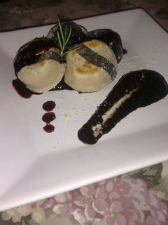 Una foto de Sorrentinos a la plancha de pollo a la mostaza con champiñones con salsa de tinta de calamar