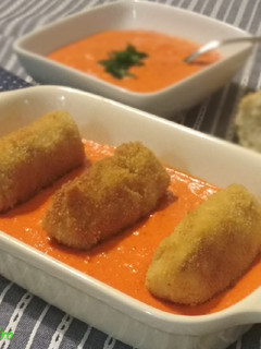 Una foto de Croquetas de patata y bacalao sobre crema de piquillos