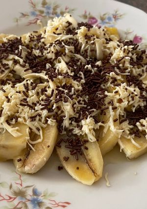 A picture of Banana in cheese n cocoa sprinkles.