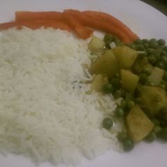 A picture of Stewed peas and potatoes served with white rice.