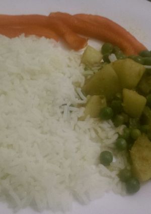 A picture of Stewed peas and potatoes served with white rice.