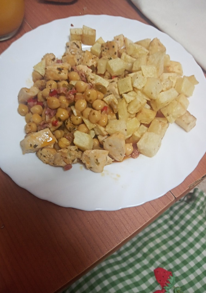 Una foto de Garbanzos compuestos con pechuga de pollo y papas fritas