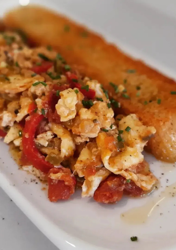 Una foto de Huevos revueltos con pisto y queso de cabra