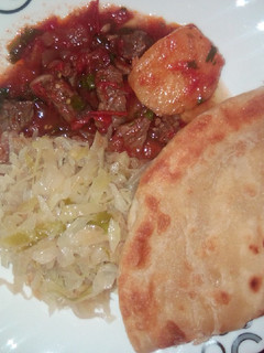 A picture of Beef stew, cabbage and chapati.