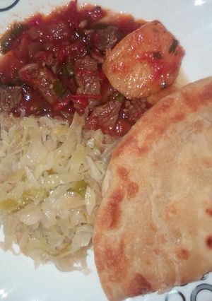 A picture of Beef stew, cabbage and chapati.