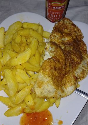 A picture of Chips,fried egg and sweet n chili sauce.