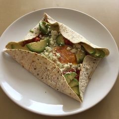 A picture of Breakfast tortilla with egg and avocado.