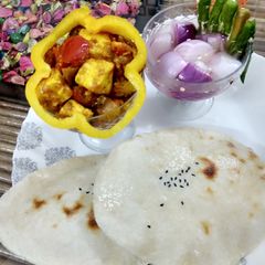 A picture of Suji naan with achaari paneer and sirke wala pyaaz.