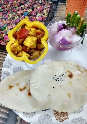A picture of Suji naan with achaari paneer and sirke wala pyaaz.