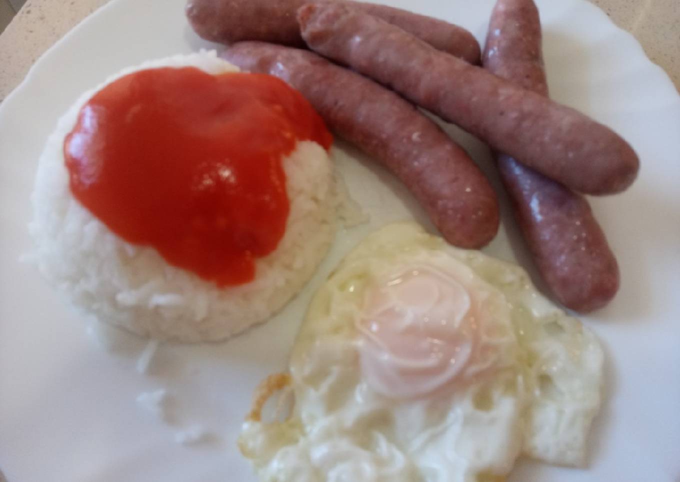 Salchichas frescas al vino con arroz blanco con tomate y huevo