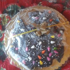 A picture of Homemade dark chocolate  coated with  colourful  chocolate sprinkles.