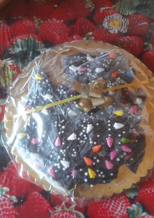 A picture of Homemade dark chocolate  coated with  colourful  chocolate sprinkles.
