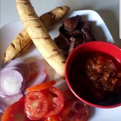 A picture of Homemade baked plantain suya and sauce.
