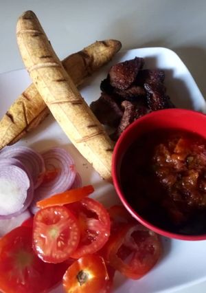 A picture of Homemade baked plantain suya and sauce.