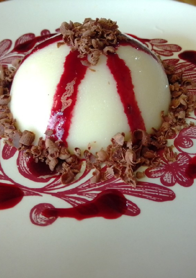 Una foto de Panna cotta de coco con coulis de zarzamora 🥥