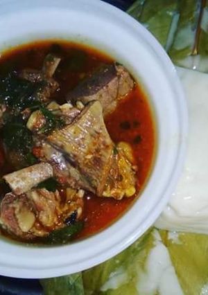 A picture of Grilled Goat Meat Pepper Soup paired with Agidi.