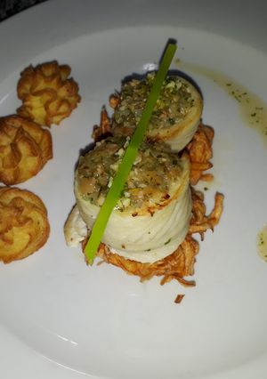 Una foto de Roule de lenguado relleno con duxelle acompañado con puré dùchese + salsa cremolata
