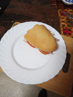 Una foto de Medio bocadillo de escarola, tomate, jamón y queso tierno