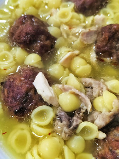 A picture of Sopa de pollo y verduras con conchitas y albóndigas.