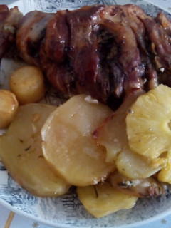 Una foto de Paletilla de cordero asado con patata panadera y piña y romero