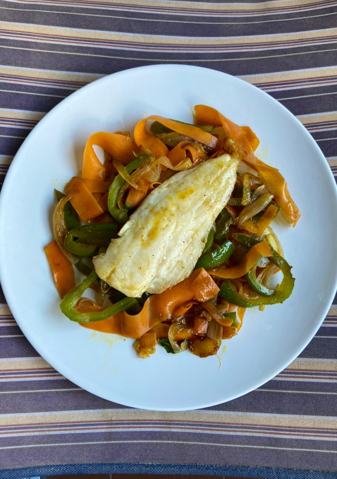 Una foto de Merluza a la plancha en cama de verduras