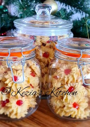 A picture of Kue Sumprit Mawar Issy (Shaped Cookies with Cherry on Top).