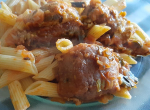 Una foto de Albóndigas de merluza en salsa con penne rigate